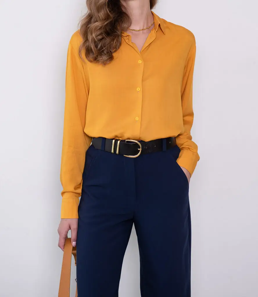 Gelbe Bluse zu dunkelblauer Hose mit schwarzem Gürtel