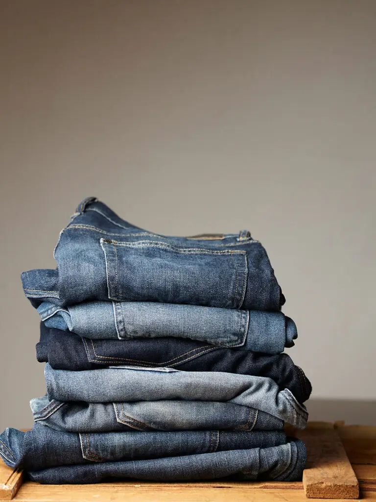 Stapel gefalteter Jeans in verschiedenen Blautönen